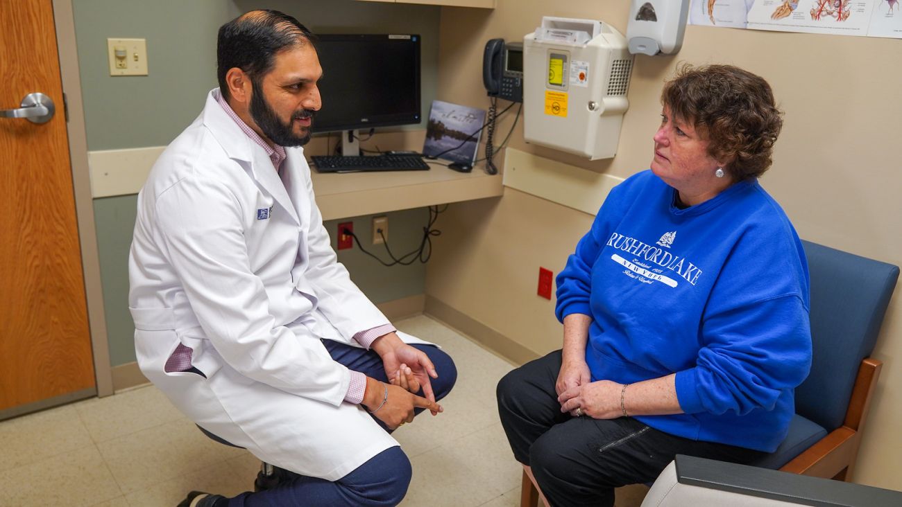 Dr. Ajay Abad consults with a patient before receiving Chemotherapy.