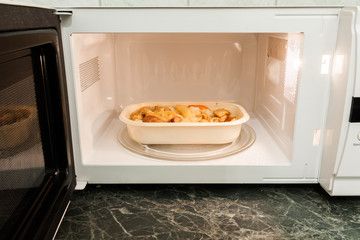 Microwave containing food in a plastic container
