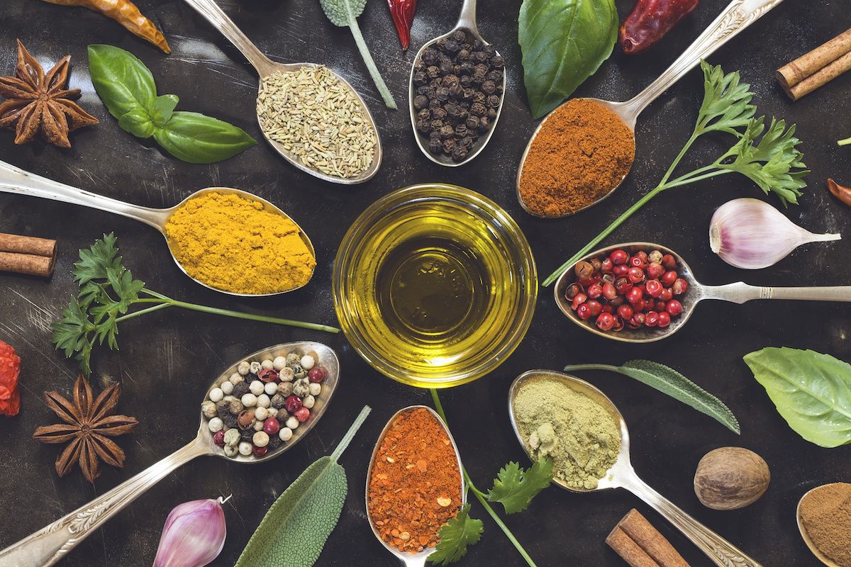 Spoons filled with colorful spices and a small cup of olive oil