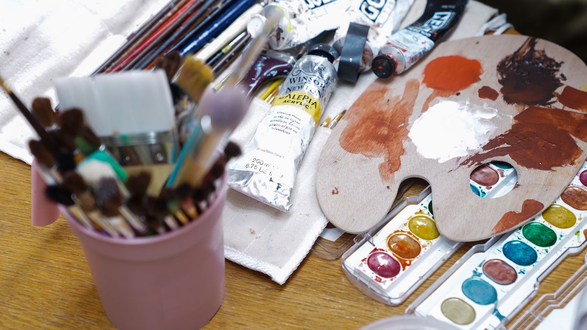 Watercolors, paint tubes, brushes, and other art supplies