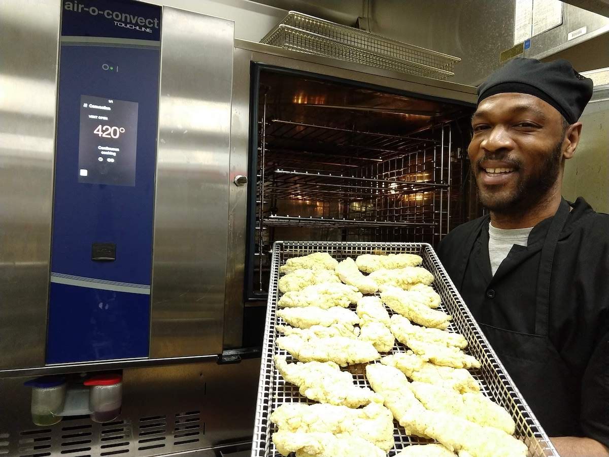 Lorenzo Clapp prepares a tray of chicken tenders for Roswell Park's new combination oven.