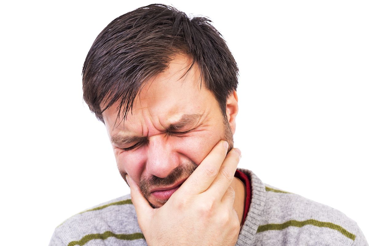 Man in pain holding his mouth