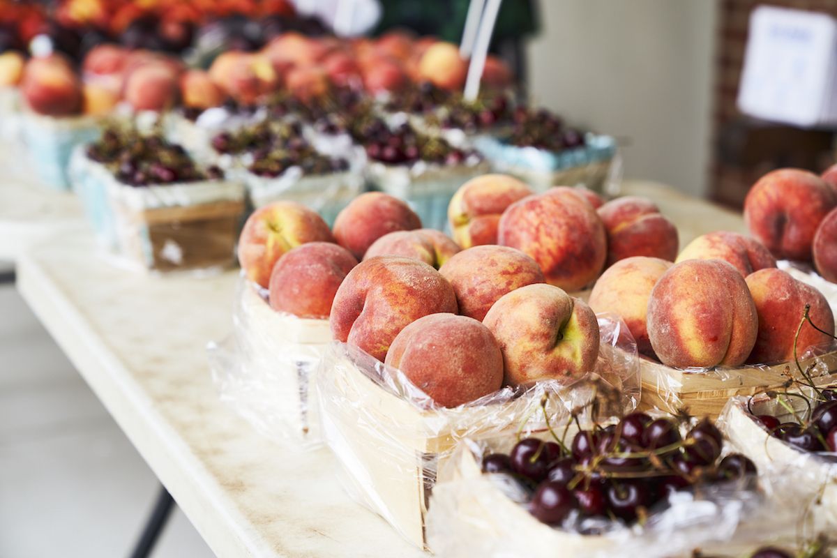 Peaches and cherries displayed at a farmers market