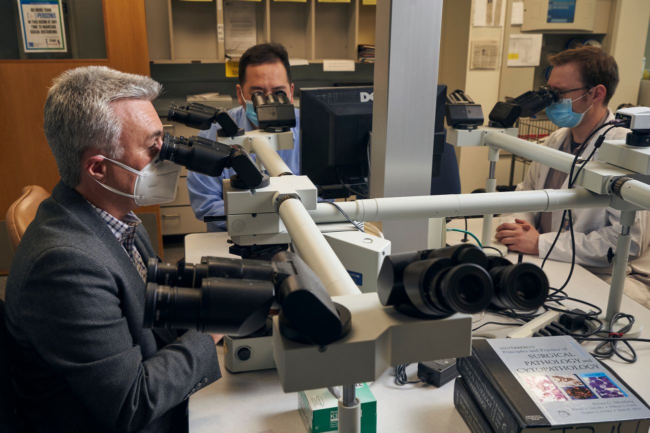 Dr. Mihai Merzianu with team looking at slides