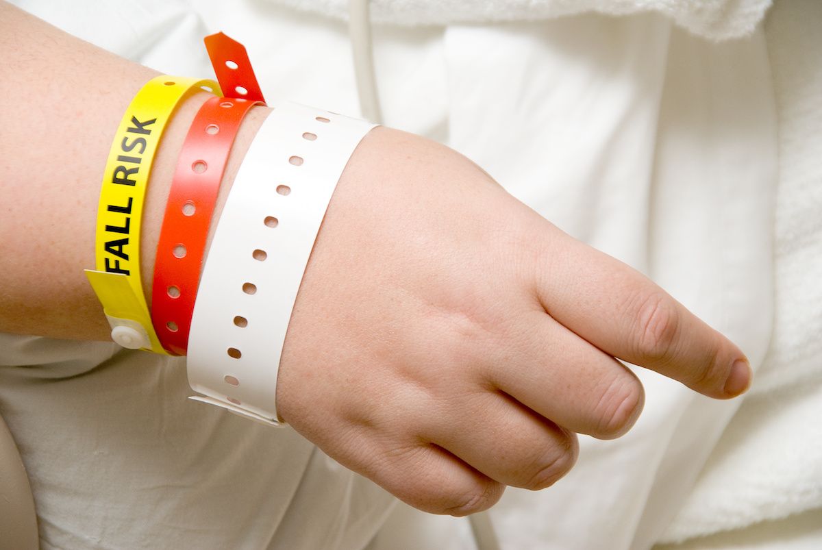 A yellow band on a patient's wrist says "Fall Risk."