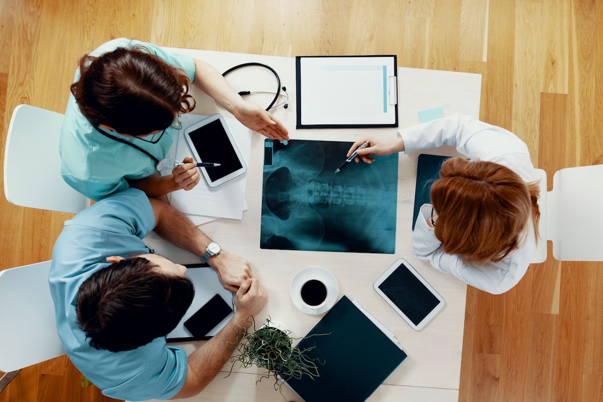 Doctors seated at a table, looking at xray