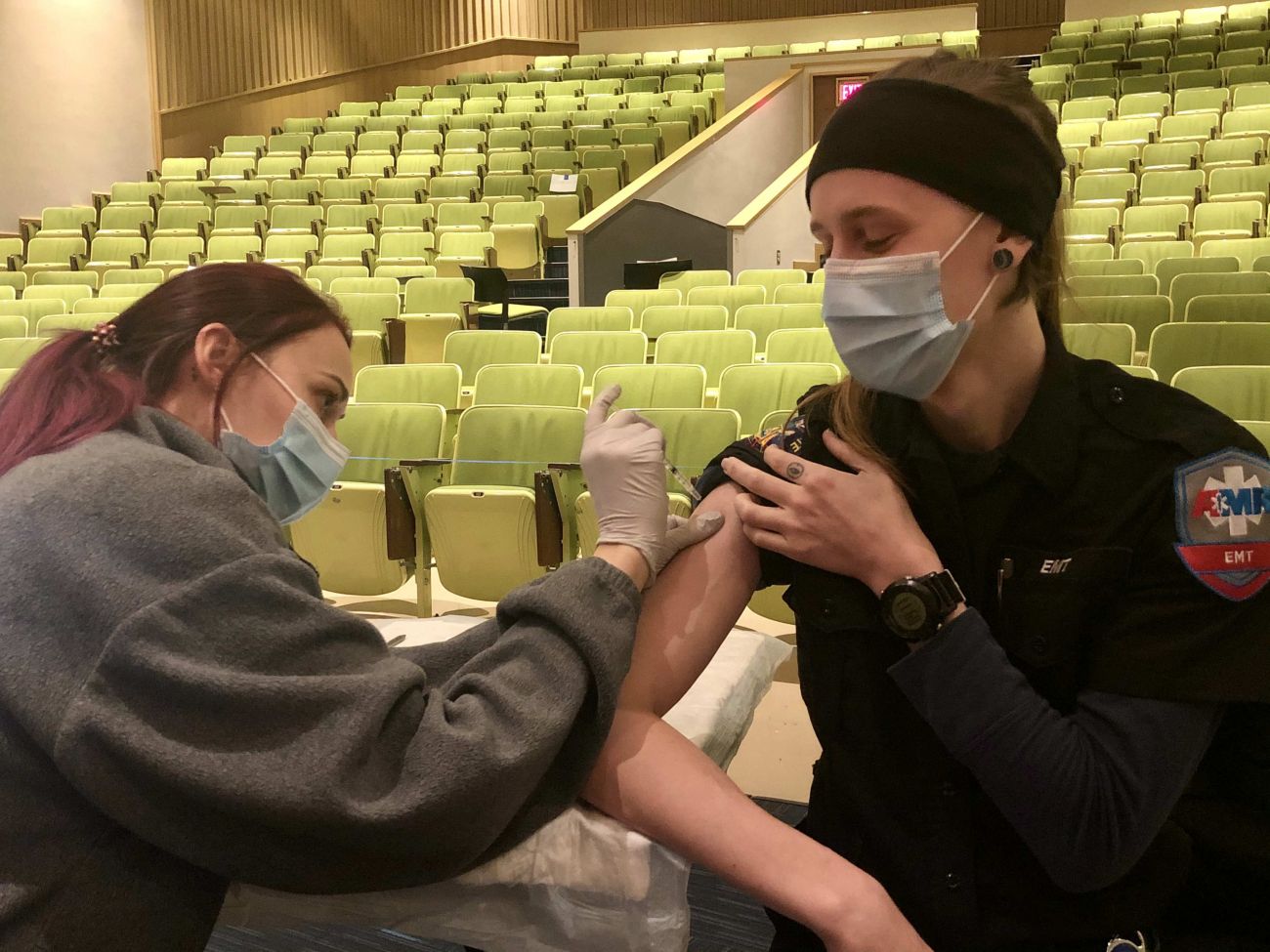 EMT Billie Henry sits for the vaccine