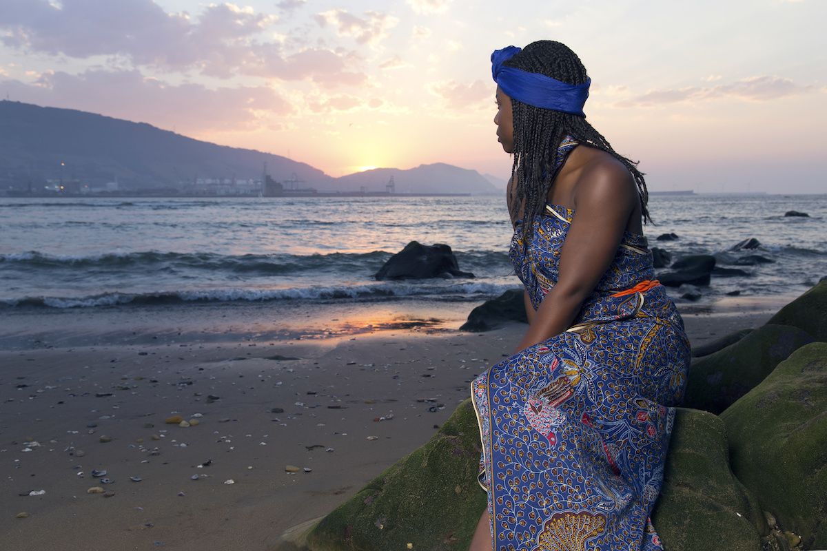 Woman looking out at the sunset above the ocean