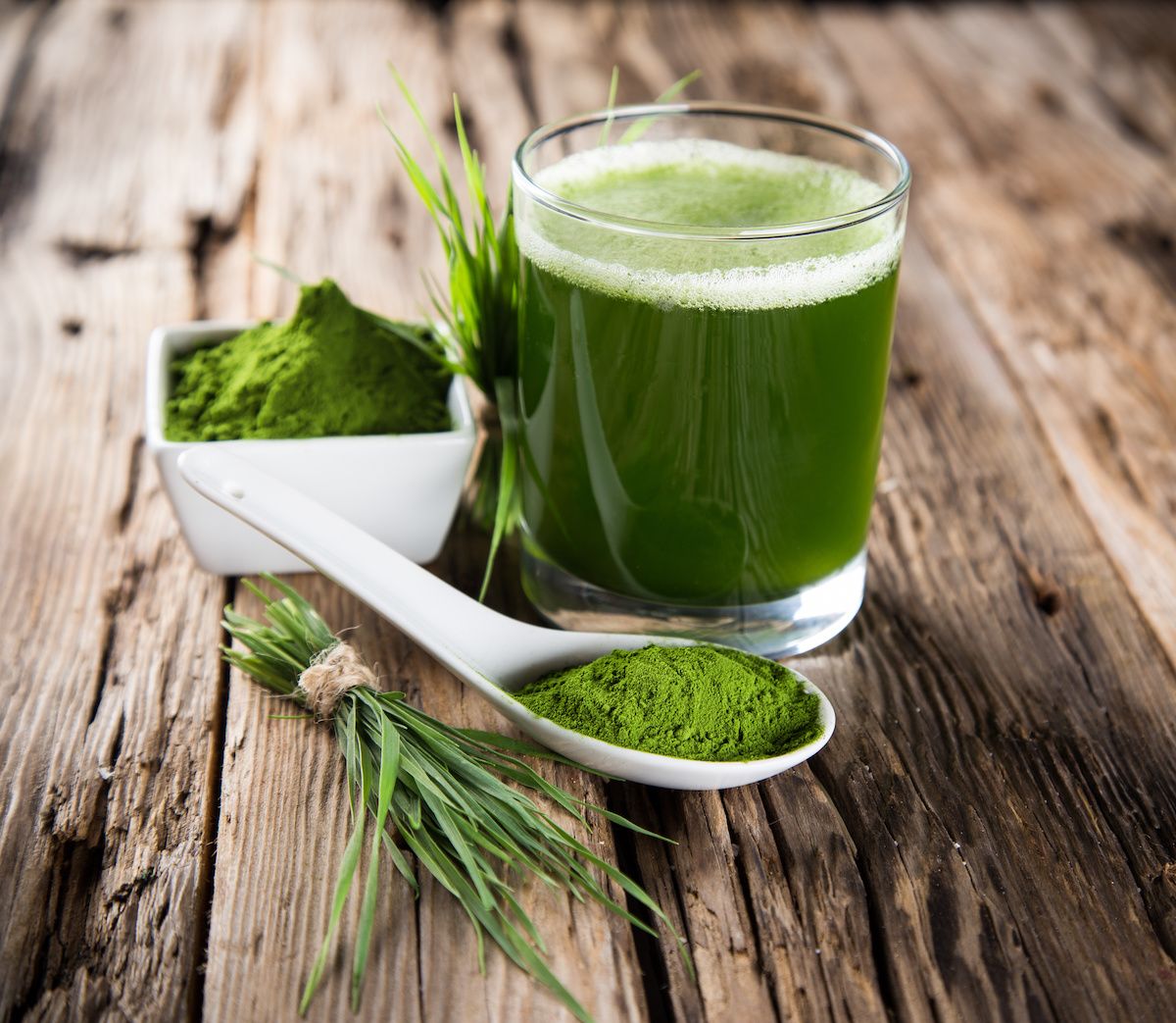 A cup of matcha tea sitting on a wooden plank