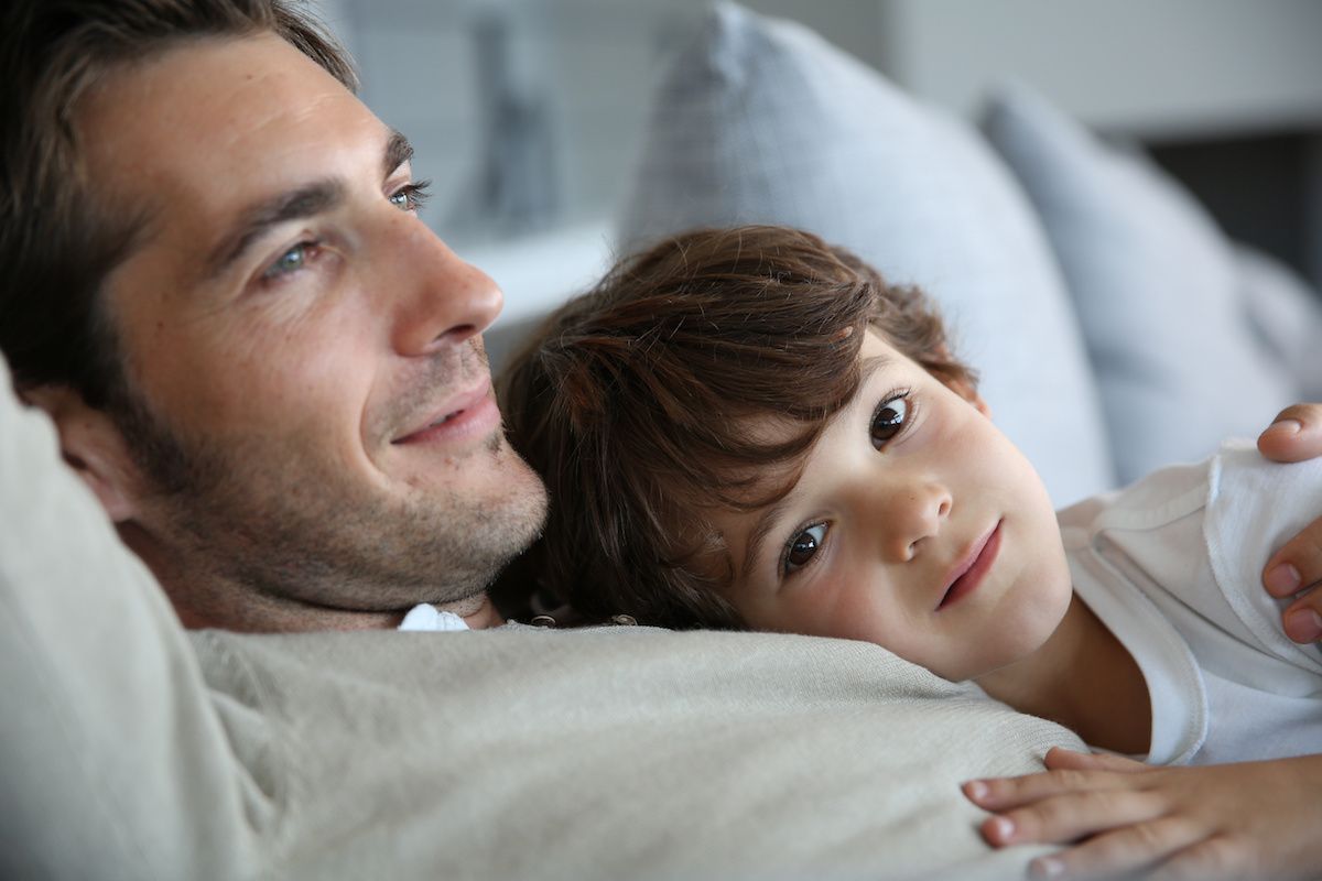 A father with his son laying on a couch