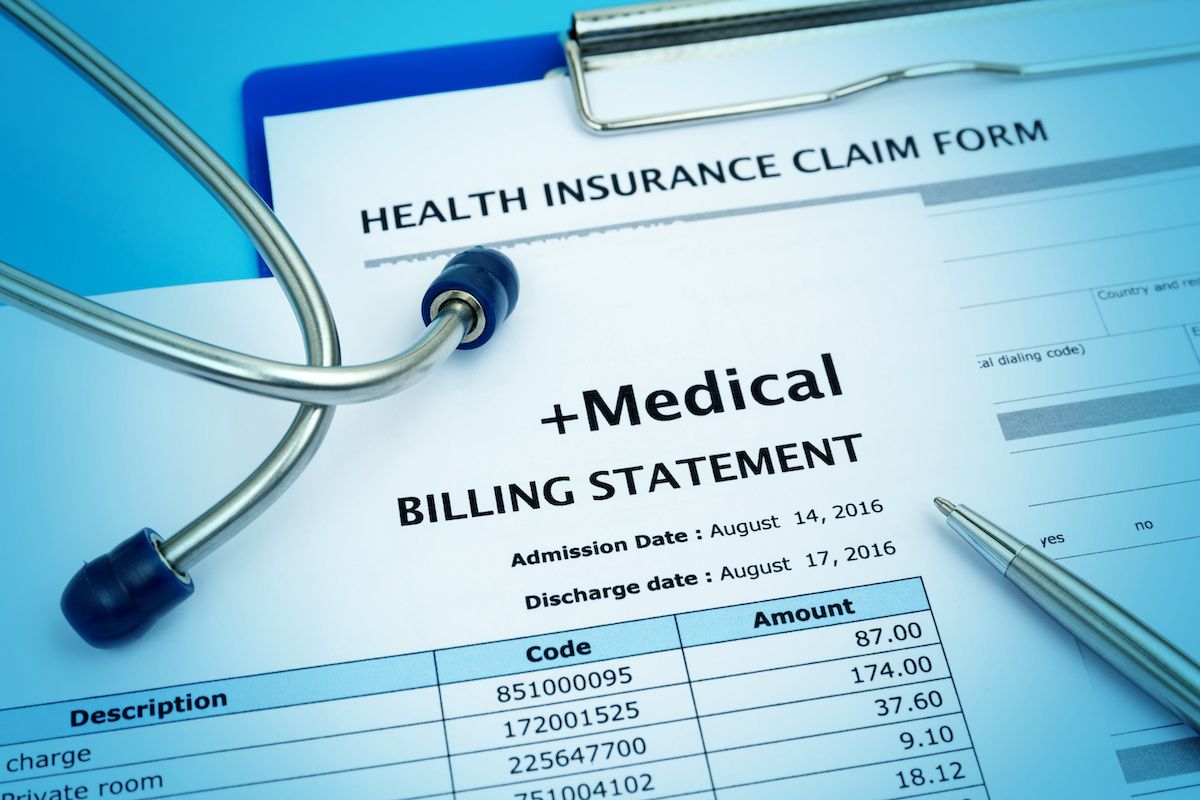 Medical billing statement with pen and stethoscope arranged on top