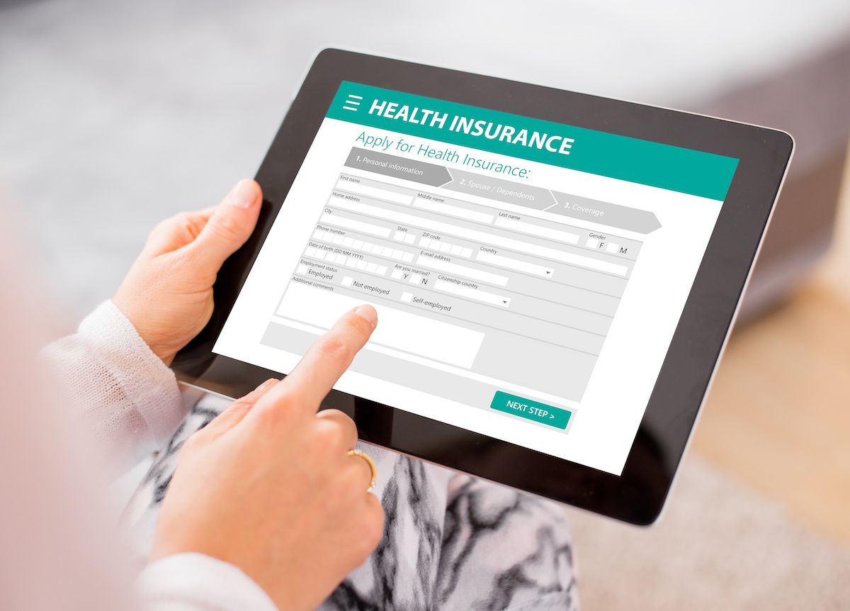 Person using a tablet to compare health insurance plans