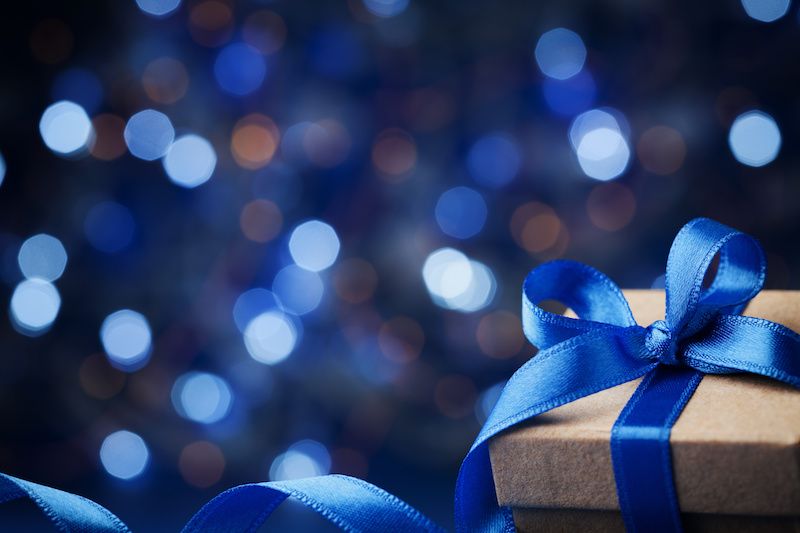 Gift wrapped in a box in front of a blue background