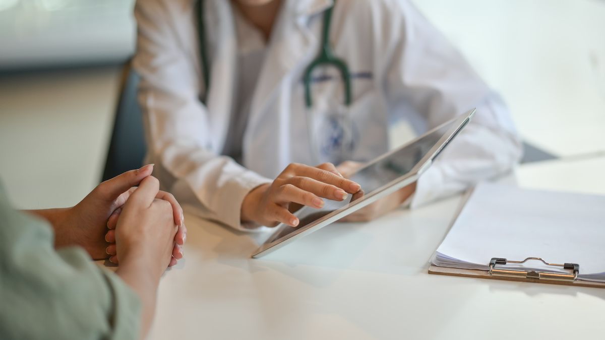 Medical professional showing a patient information using a tablet