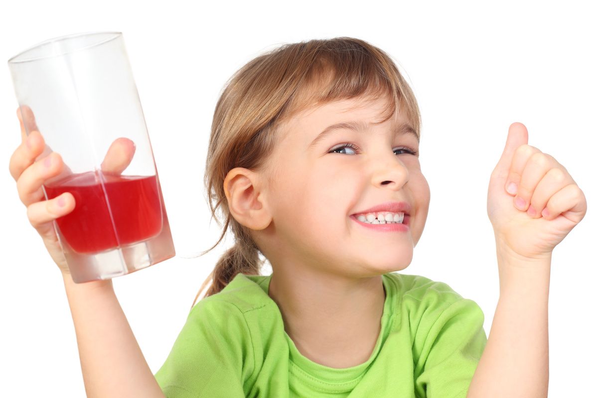 Young girl holding a glass of red fruit punch