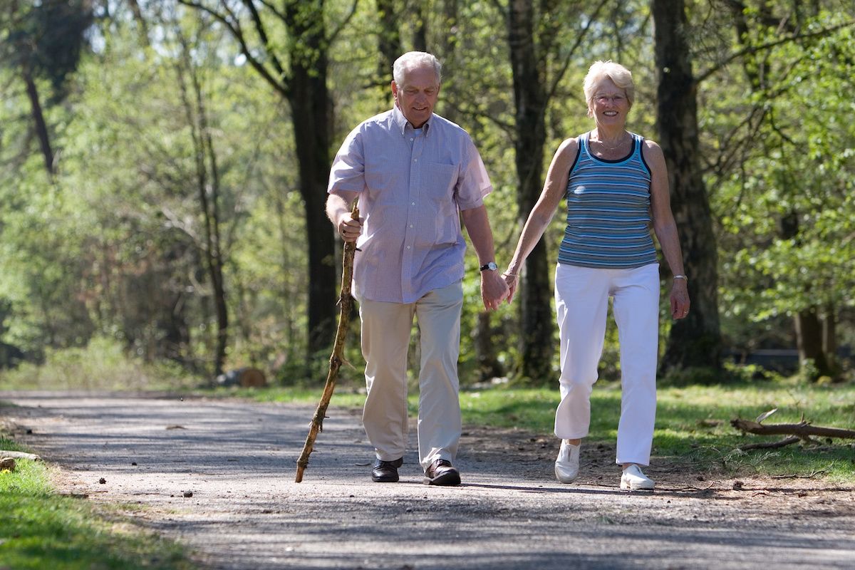 Two older people walking outdoors for exercise