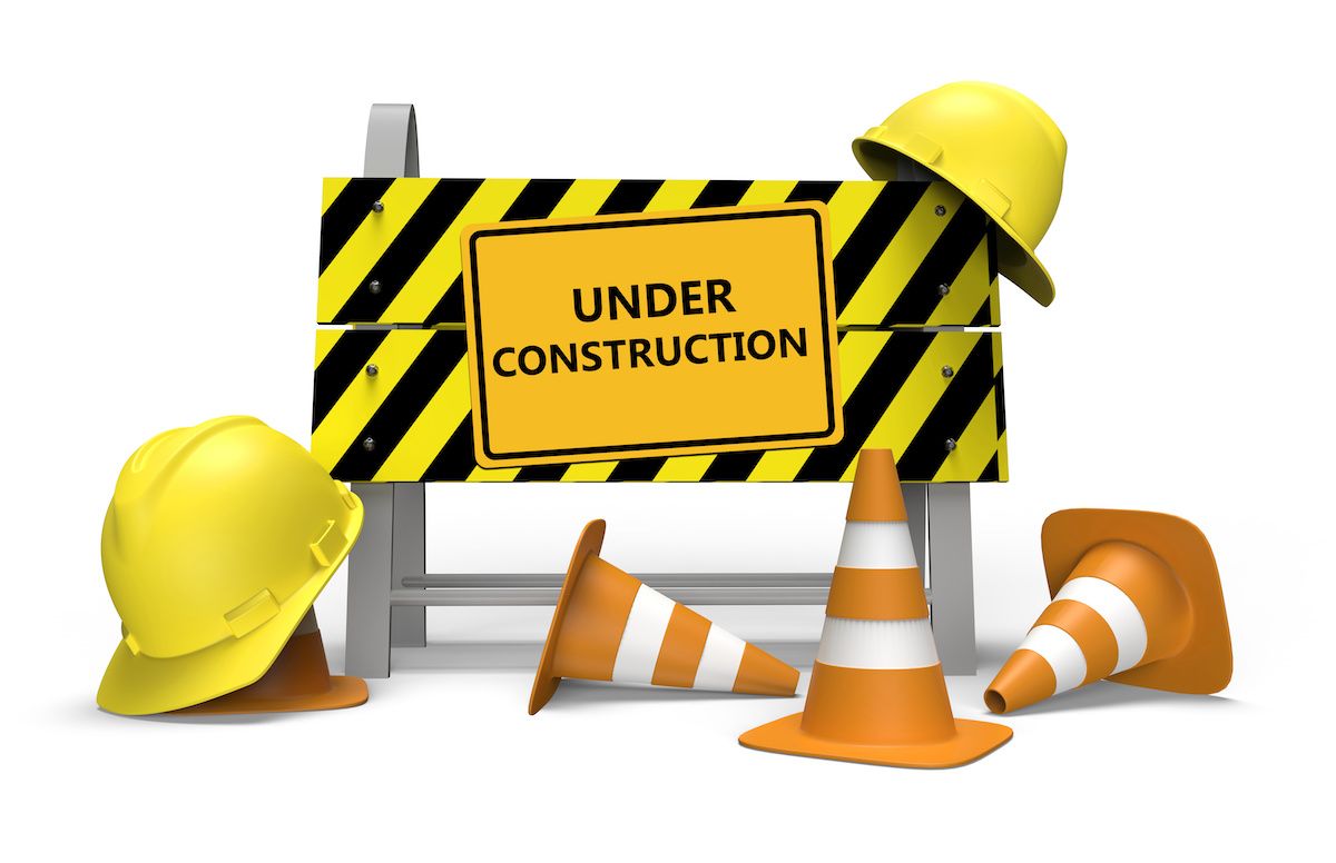3D rendering of construction barrier with a sign that reads "under construction". Cones and construction hats are placed around the construction barrier.