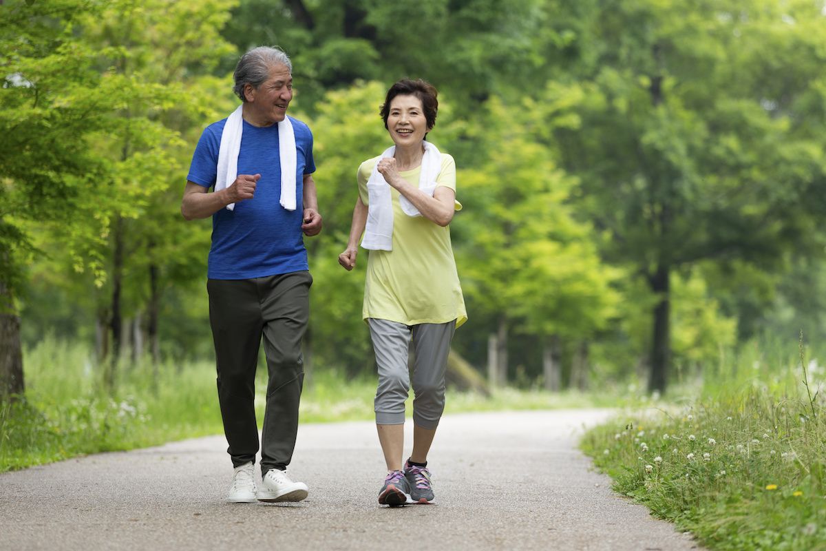 Two older people walking outdoors for exercise