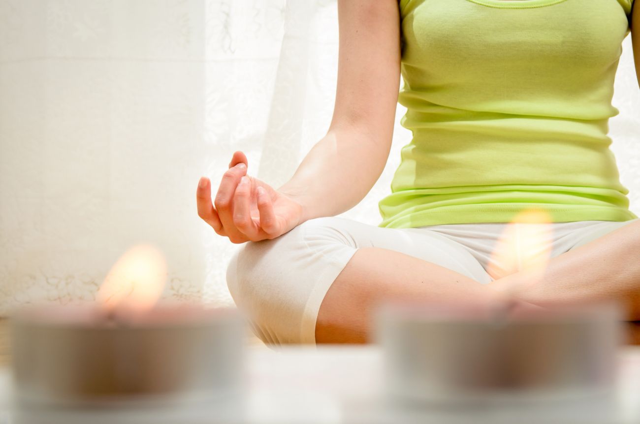 Person meditating with candles