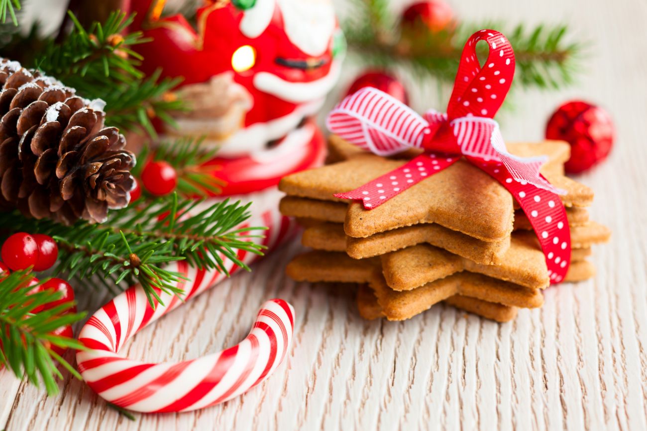 Candy canes and cookies on a holiday themed background