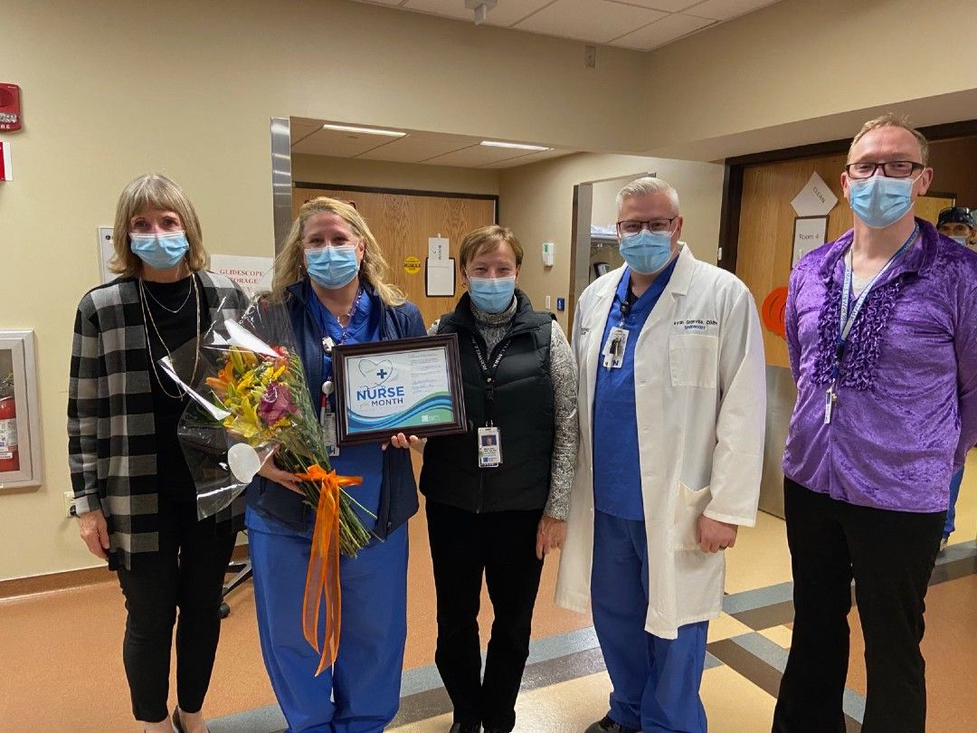 Dr. Candace S. Johnson, left, presents Kelley Watson with flowers and a certifcate for being named Nurse of the Month for November.