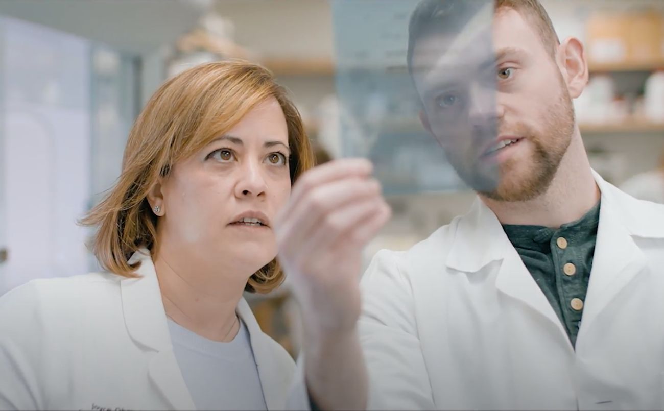 woman and man look at an item in the lab