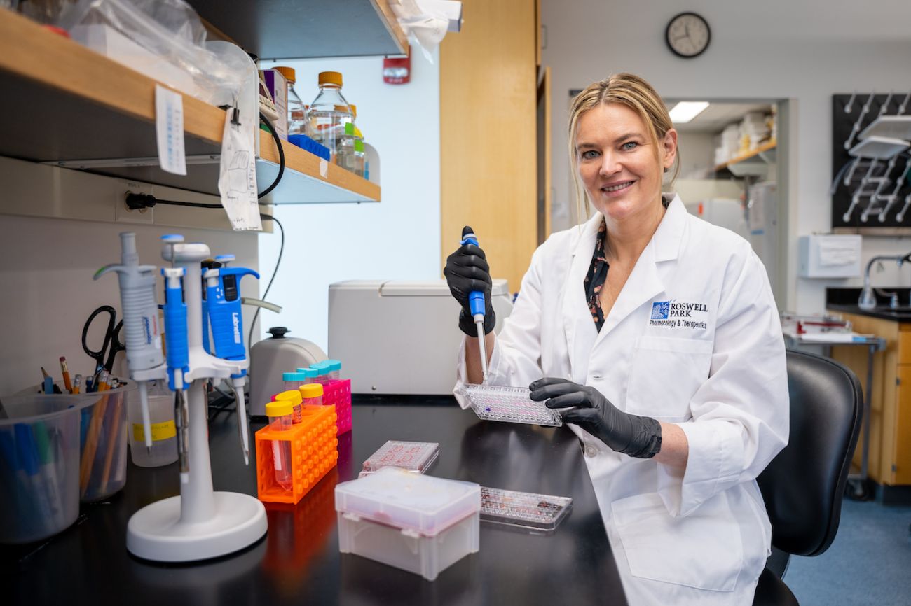 Dr. Anna Woloszynska sit at a table in her lab. 