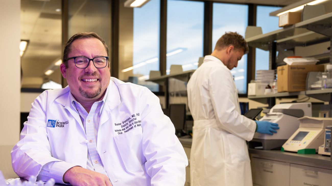 Dr. Brentjens sitting at a desk in his lab