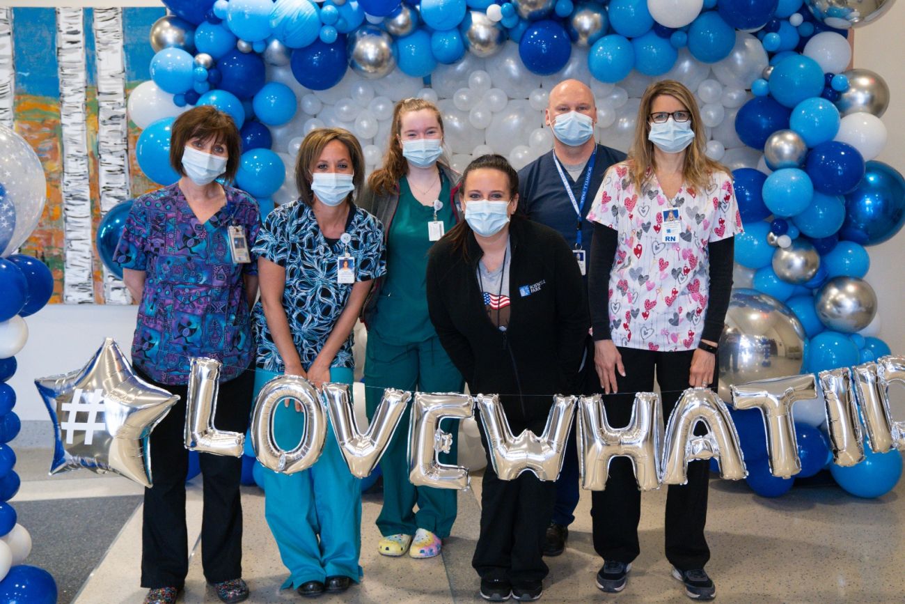 Nurses stand with a balloon banner