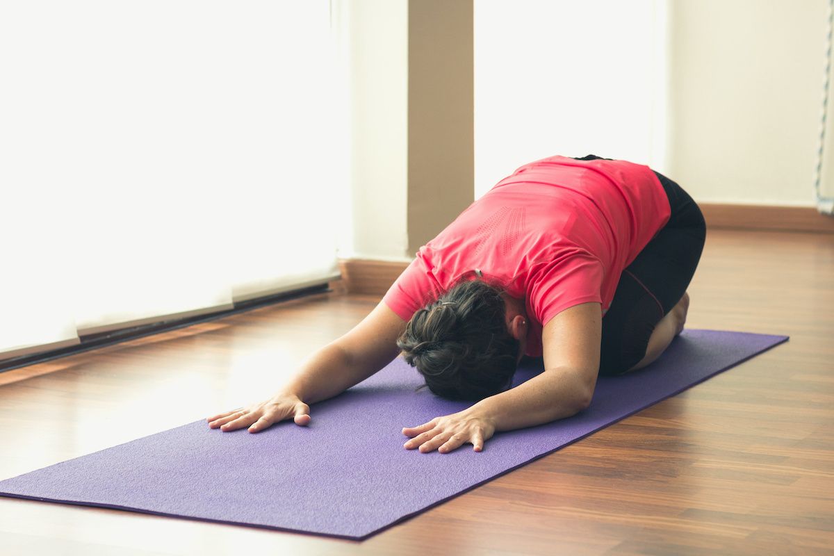 photo of woman performing yoga child pose