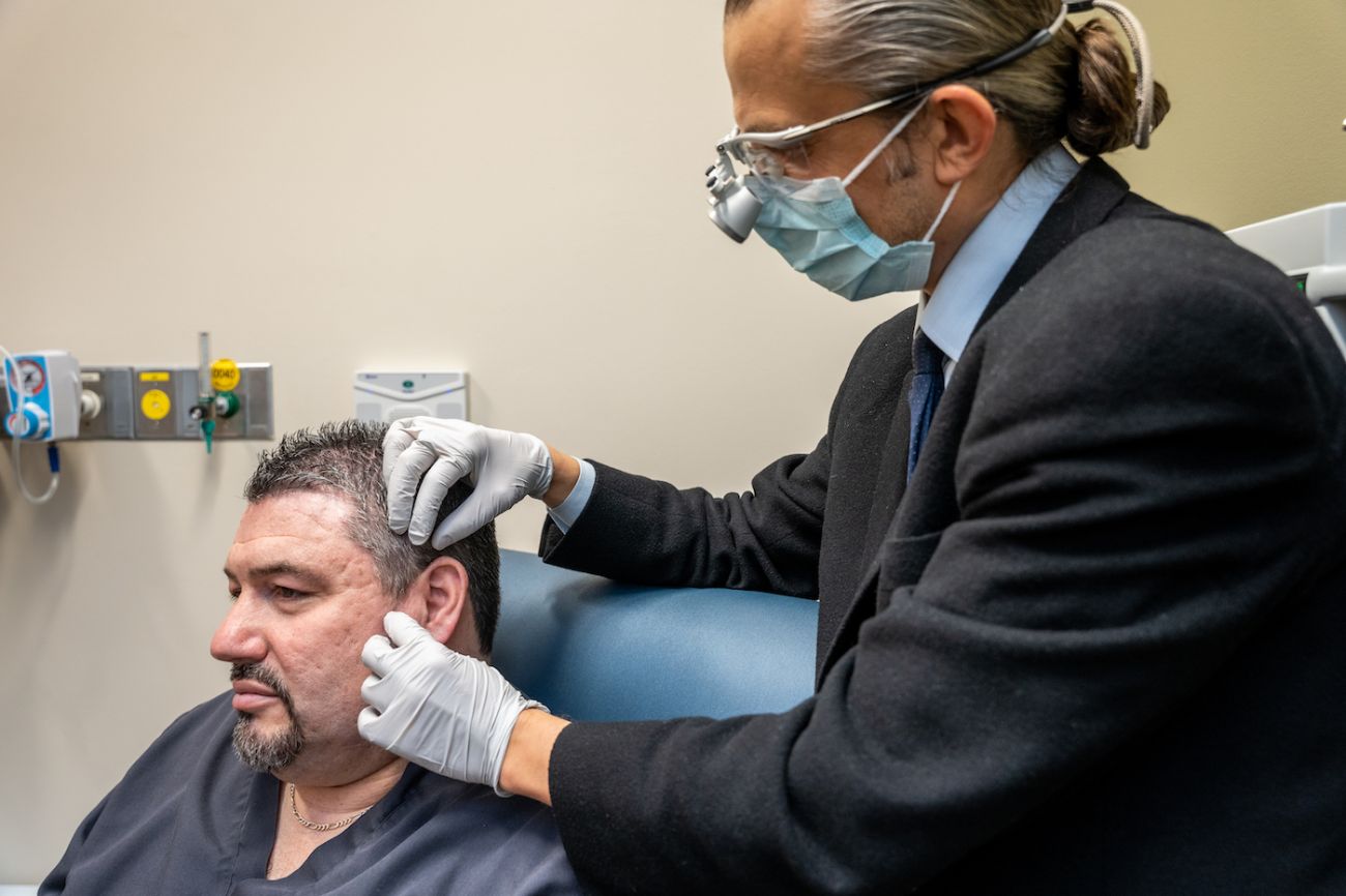 Dr. Can Ozturk in-clinic examining a patient