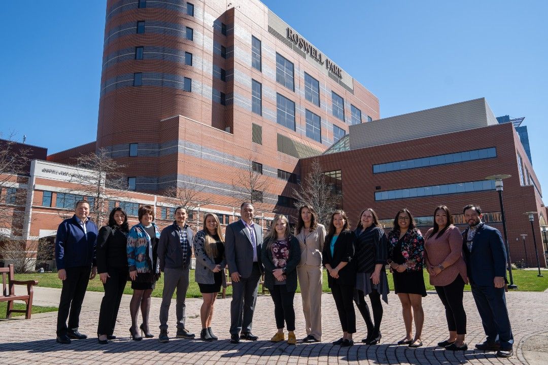 The staff of the Center for Indigenous Cancer Research stands in front of Roswell Park Comprehensive Cancer Center. 