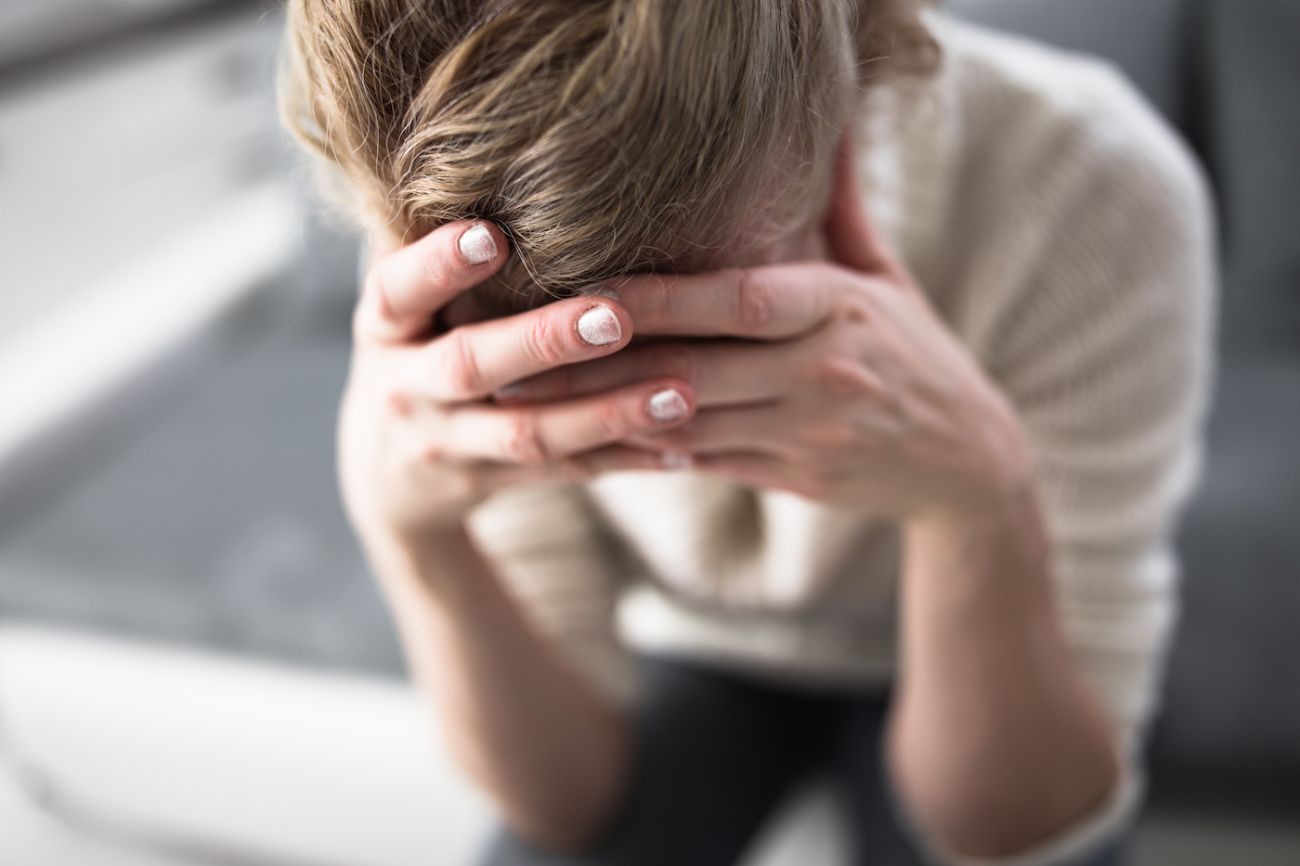 Photo of woman holding hands to head - stock