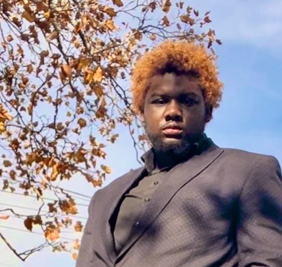 Young man with red hair in black suit