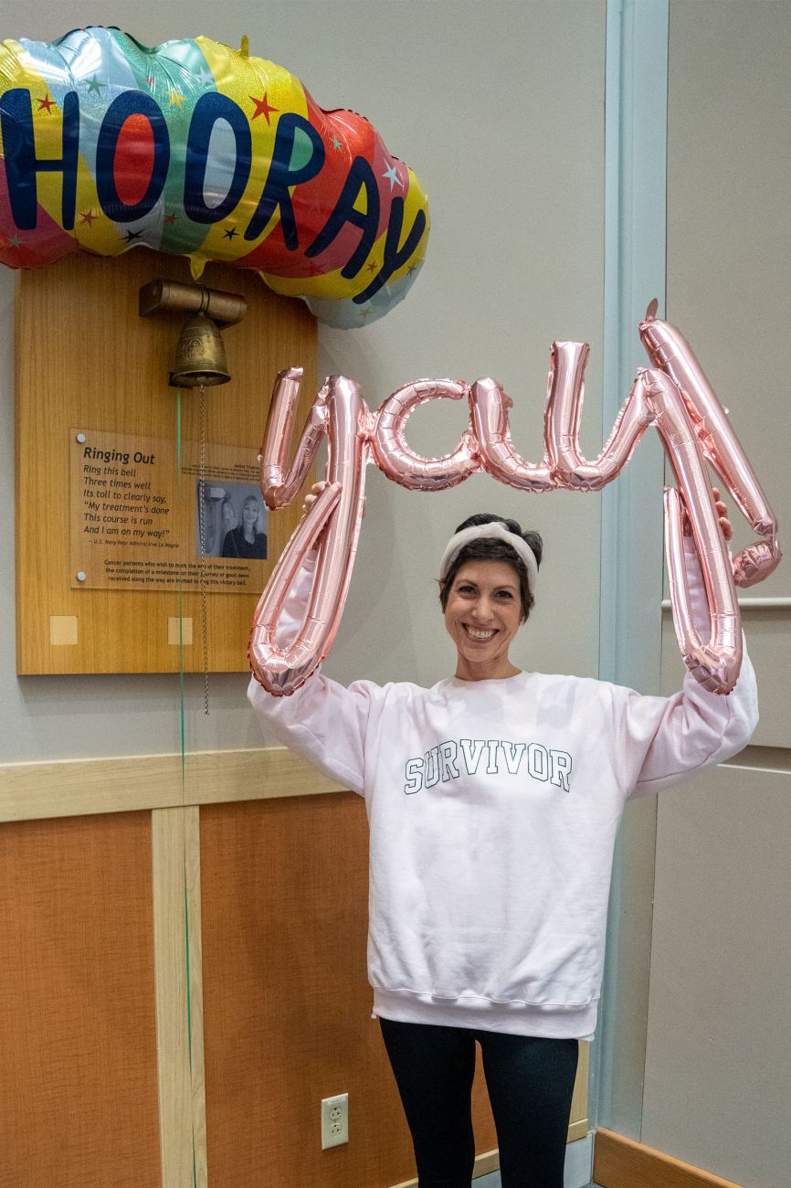 Kristin Scobey holding balloons in front of victory bell