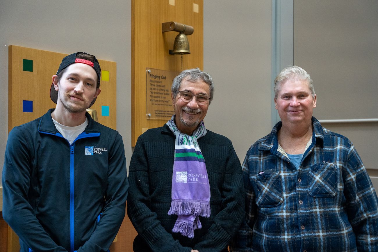 Nick Morrison, Paul Dublino and David Peek (from left) stand in front of the Victory Bell. 