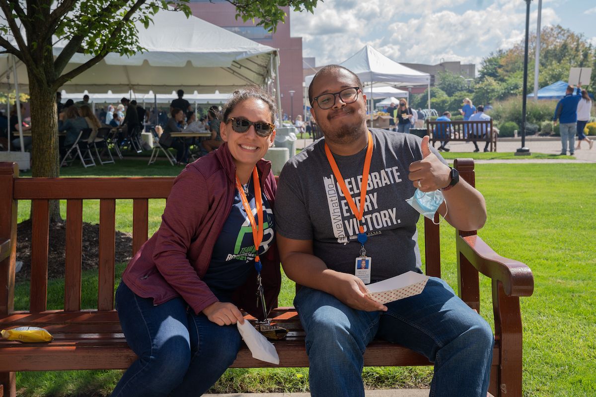 Two people eating on a bench