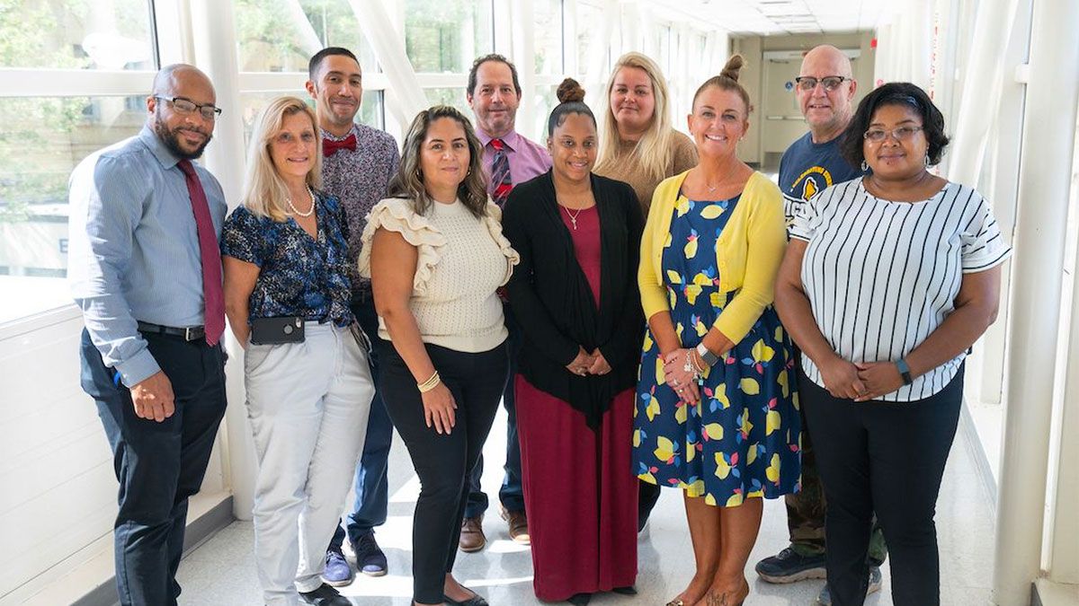 Diverse grouping of Roswell team members posing for camera