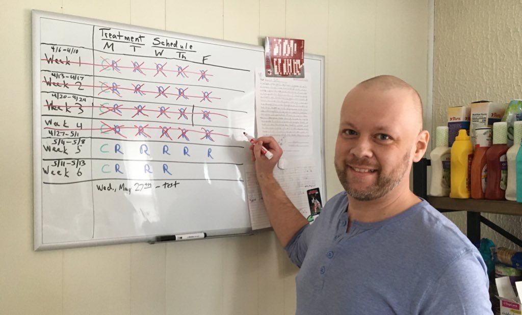 Photo of JT marking off completed treatments on his white board