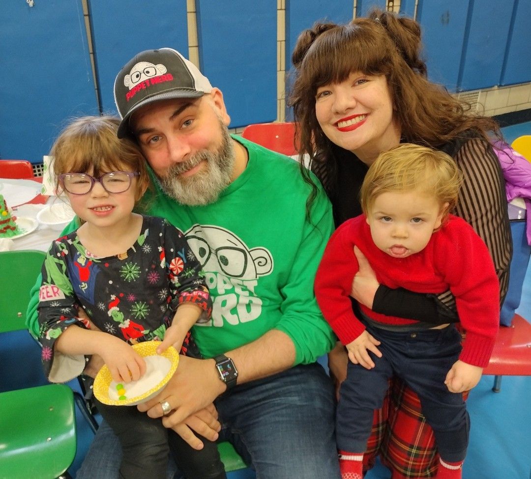 Adam and Maria Kreutinger, center, hold their two young children. 