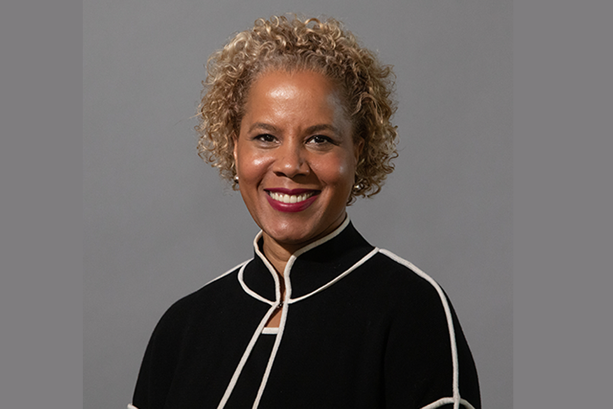 Woman in black and white top with curly blond hair