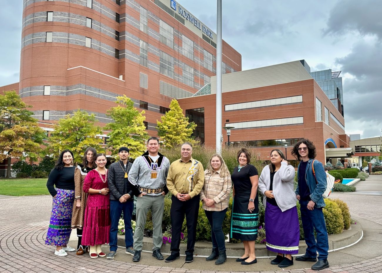 Dept of Indigenous Cancer Health poses in front of the flagpole in Kaminski Park