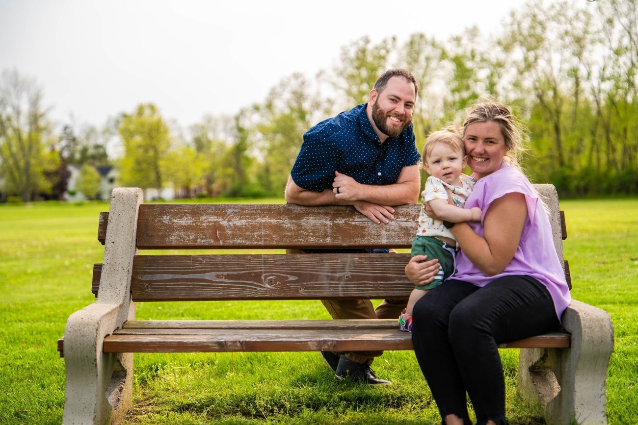 Meghan and Cody Romanos with their son, Cayden, in a park.
