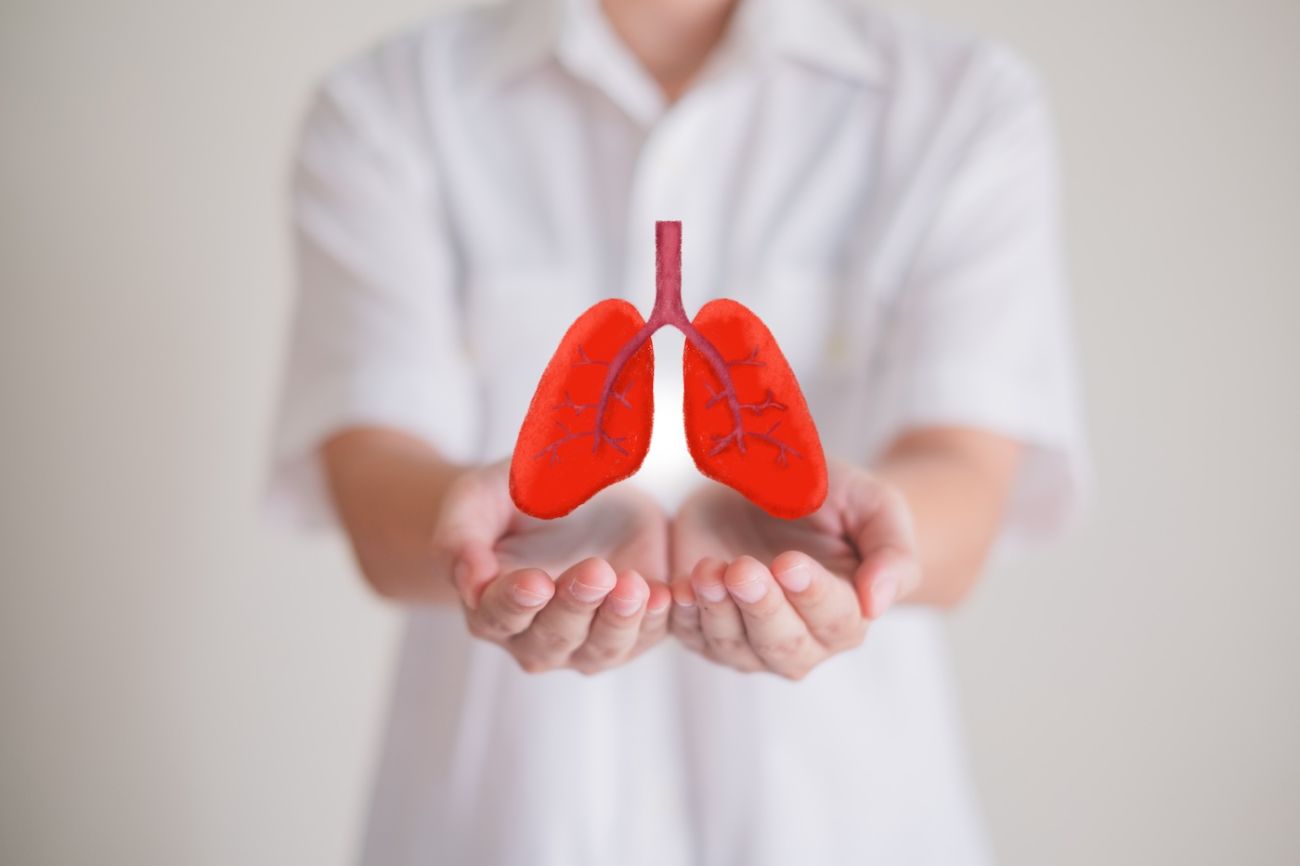 Hands holding an image of a pair of lungs