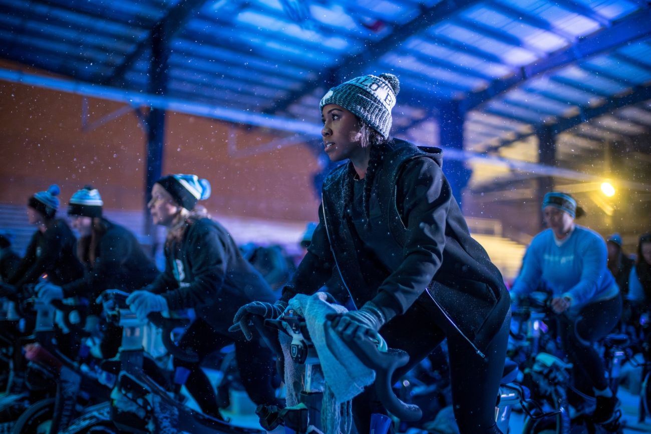 Woman riding a stationary bike outdoors in the snow