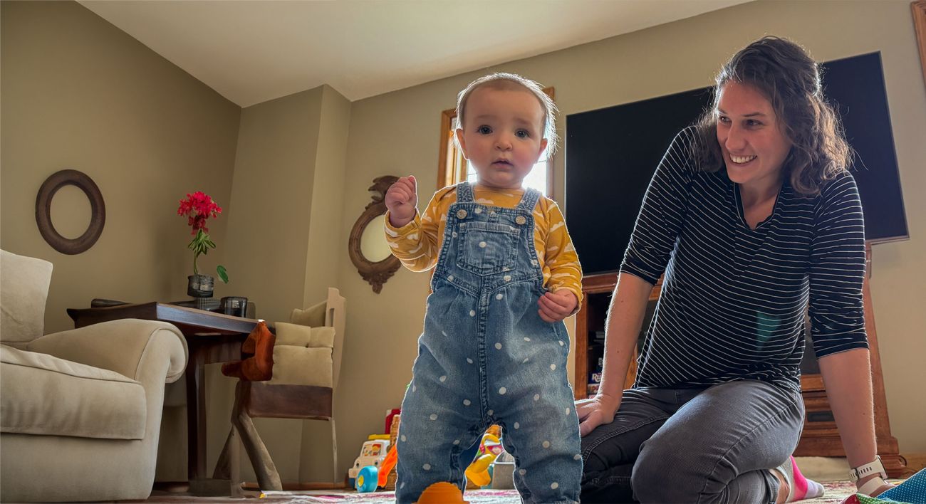 Mother looks on adoringly at her toddler. 