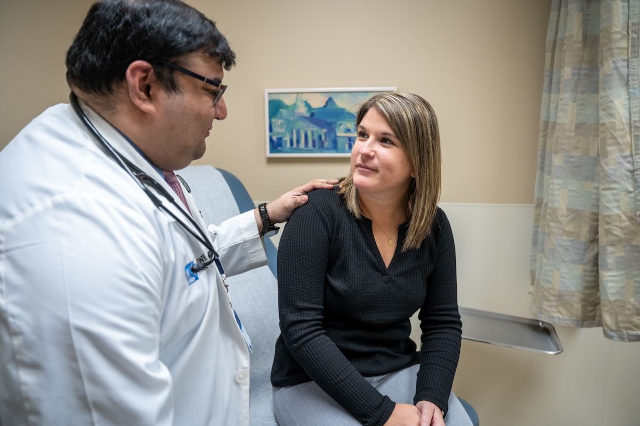 Dr. Deepak Vadehra in clinic comforting a patient