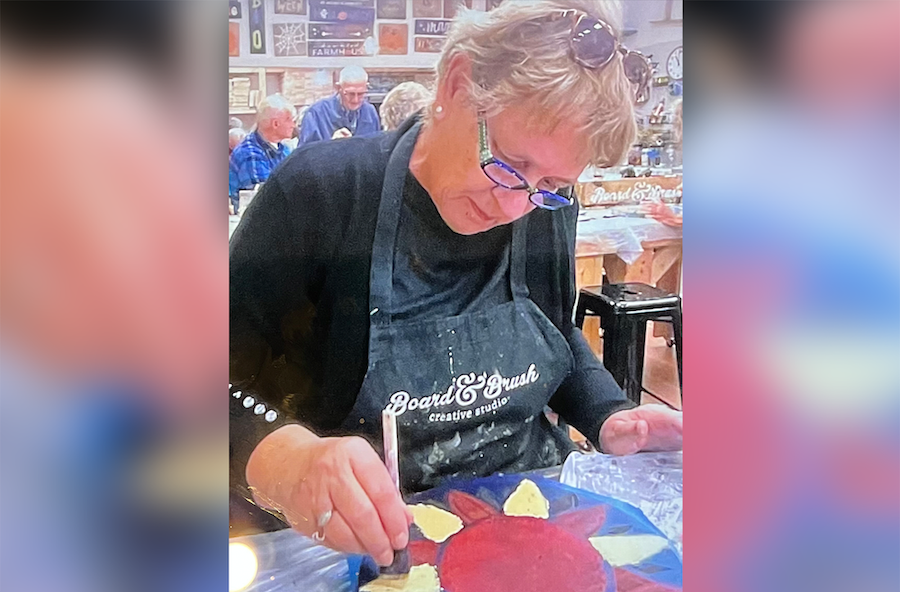 Marlea Brown, a colorectal cancer patient at Jamestown Medical Oncology, paints a picture of a flower