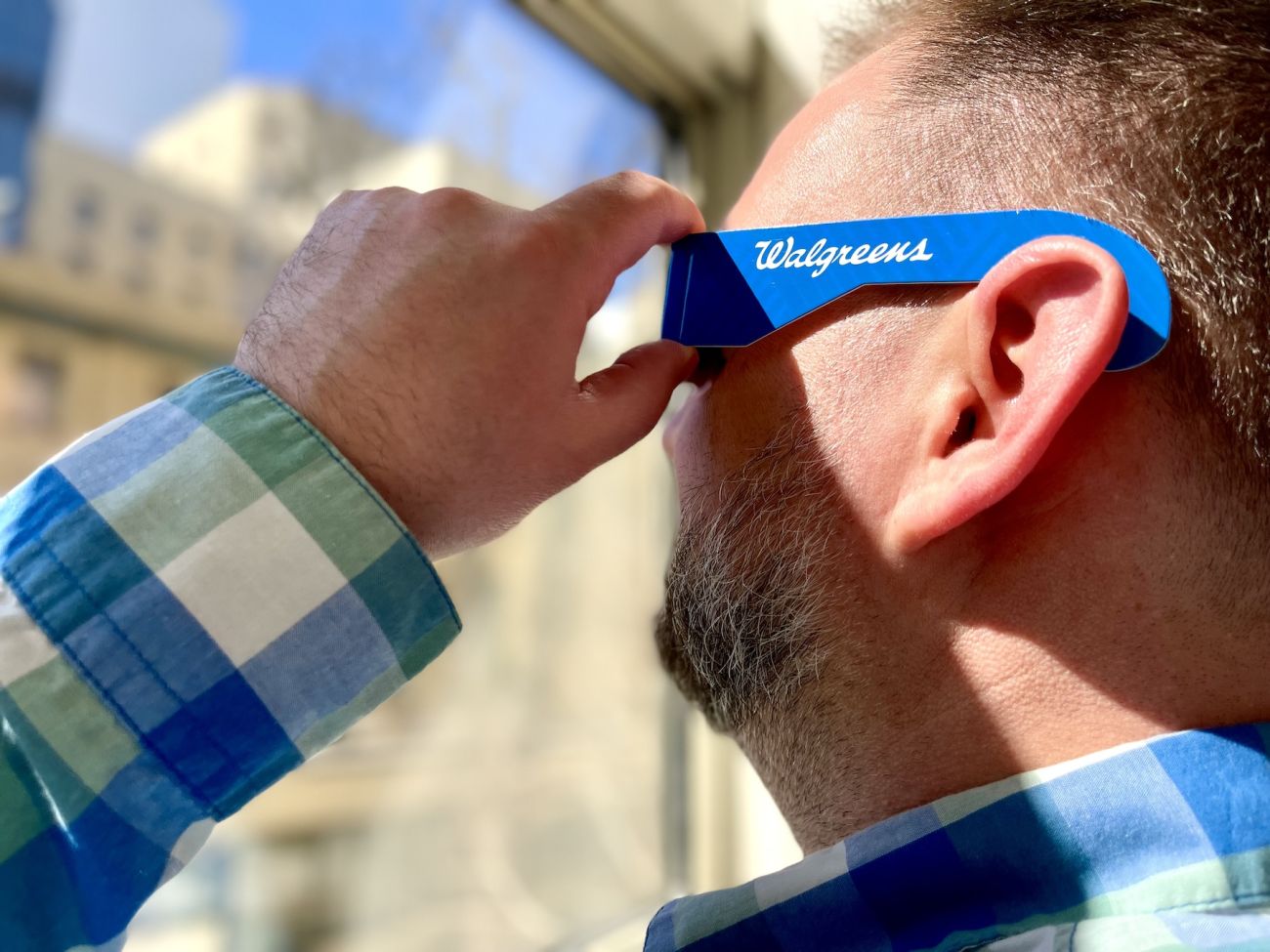 Man wearing eclipse safety glasses looking at the sun