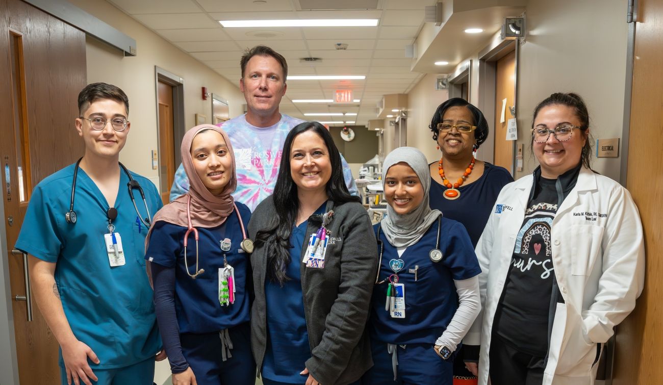 A group of nurses smile in a hallway